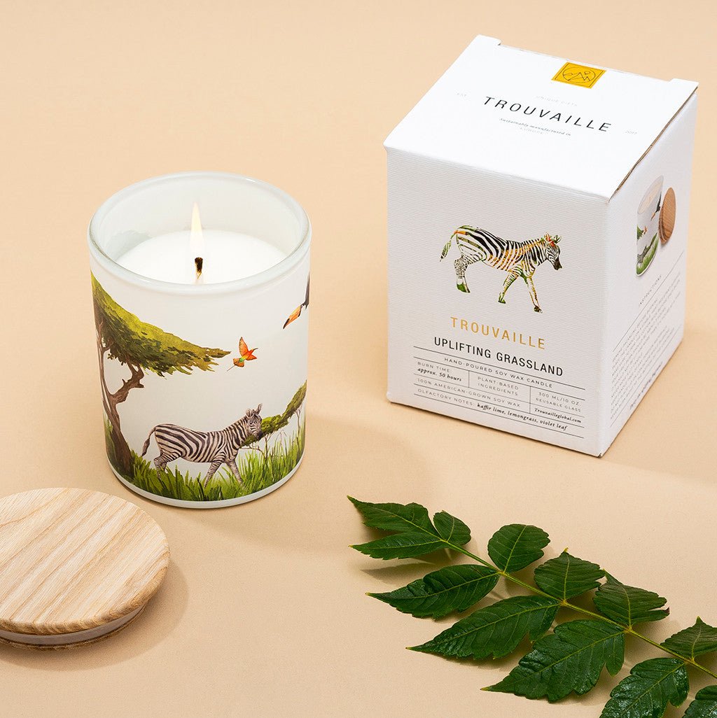 Candle with a zebra design on a white surface with a matchbox in the background